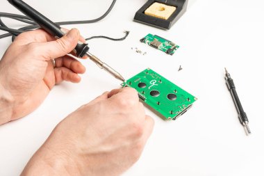 bir masa üzerinde bir devre kartı lehim kişi