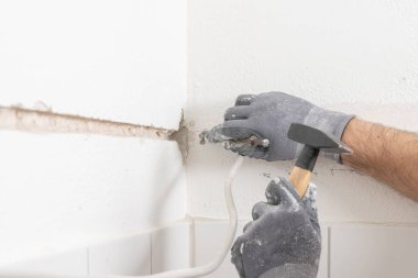 bir zanaatkar bir duvara bir yarık yumruk