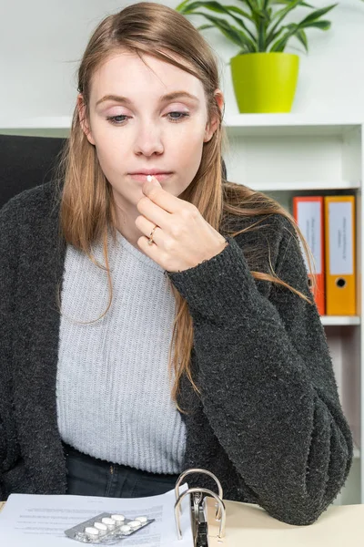 Mladá žena v kanceláři si bere léky proti bolesti hlavy — Stock fotografie
