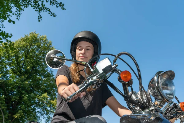Eine junge Frau fährt Motorroller und blickt in den Rückspiegel — Stockfoto