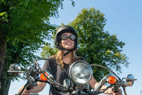 Eine junge Frau mit Helm und Brille fährt Motorroller und lächelt — Stockfoto