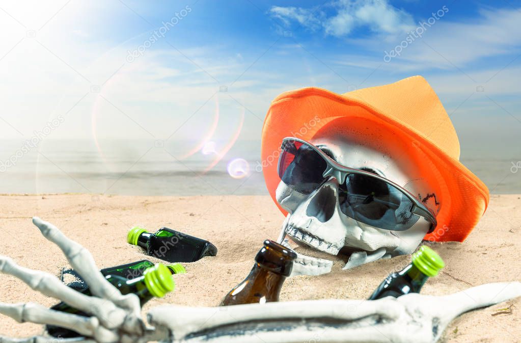 skeleton of a celebrating person died of too much alcohol on a beach