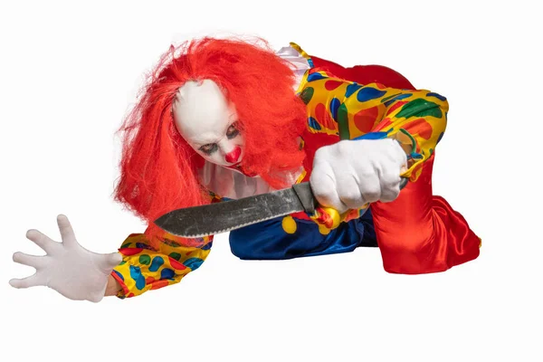 A bad clown lies on the ground and holds a knife in the camera — Stock Photo, Image