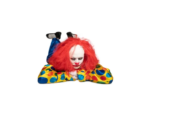 Ein gelangweilter Clown liegt auf dem Boden und blickt in die Kamera — Stockfoto