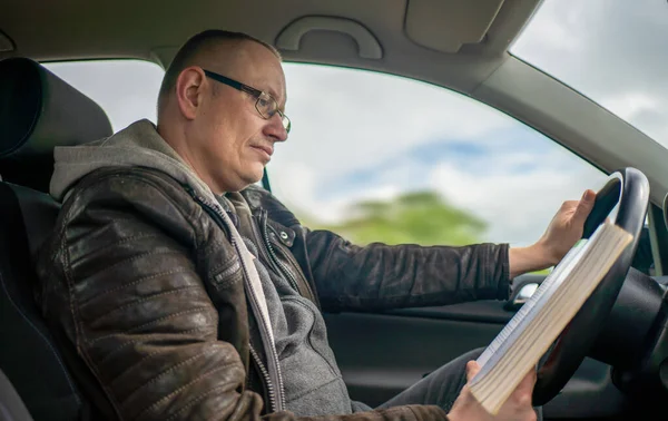 사람들은 차를 운전하면서 책을 읽고 있습니다. — 스톡 사진