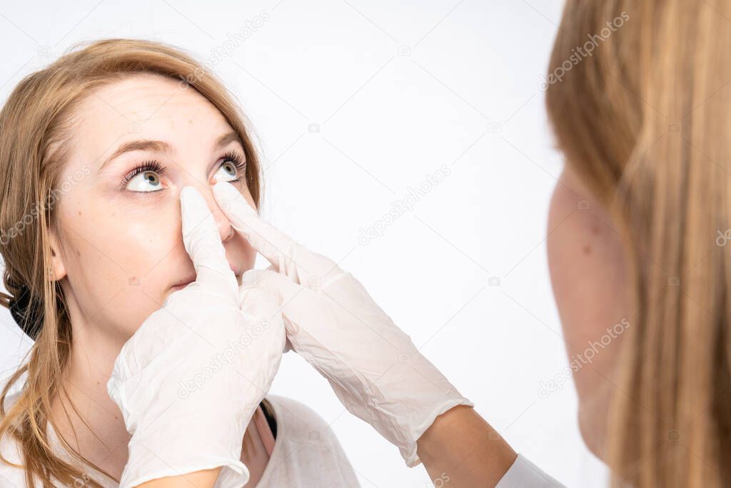a doctor examines the face of a patient with her hands