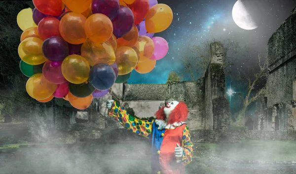 Ein Fröhlicher Clown Hält Viele Luftballons Vor Einem Gruseligen Hintergrund — Stockfoto