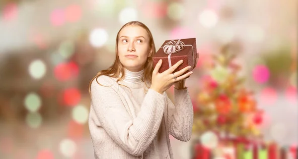 Une Jeune Femme Excitée Vérifie Son Cadeau Noël Devant Fond — Photo