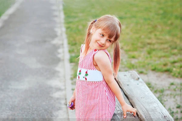 Gülümseyen kız dışında kırmızı elbise poz içinde iki ponytails ile. Mutlu çocukluk kavramı. Yatay pictire. Güzel çocuk. Metin için yer
