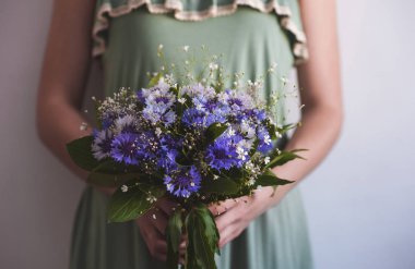 Peygamber çiçeği güzel bir buket tutan Yeşil elbiseli kız. Bahar çiçek