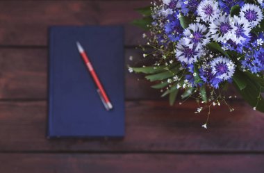 Peygamber vazo, Not defteri ve kalem ahşap arka plan üzerinde güzel bir buket. Metin için yer kopyalayın