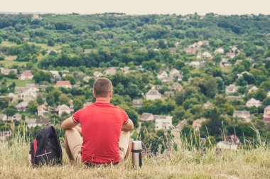Bir turist adam bir dağ üzerinde oturur ve city adlı görünüyor. Yeni ülke keşfetme