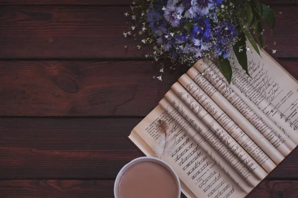 Peygamber, kitap, kahve ve ahşap masa üzerinde tüy güzel buket. Metin için yer kopyalayın