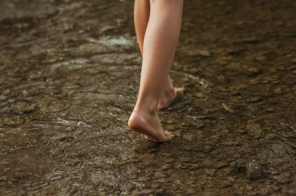 Suyun içinde çocuğun bacaklarının yatay görüntüsü. Göl kenarında yalınayak yürümek, göl kenarında su birikintisi. Metin için alanı kopyala