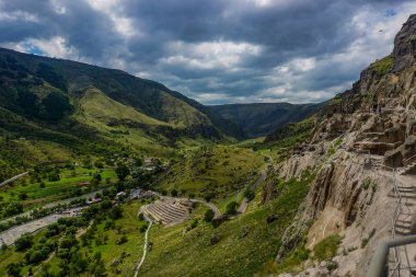 Vardzia mağaraları dağlar nehir ve yağmurlu bulutlar panoramik manzara