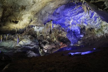 Mavi ve yeşil ışıklı Prometheus mağarasının sarkıt iç görünüm