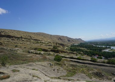 Uplistsikhe dağ manzara nehir ve mavi gökyüzü ile yaz ortak görünümünde