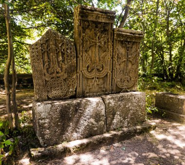Üç oyma geleneksel Ermeni taş bir parkta bir kayanın üzerinde haçlar