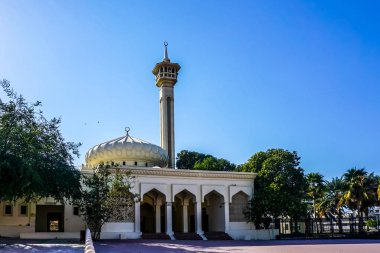 Dubai Al Farooq Camii'nin cepheden girişi görünümü minare ağaçları ve güzel mavi gökyüzü arka plan