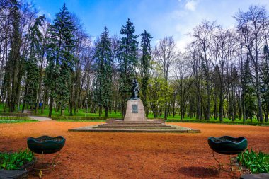 Minsk Marat Kazei anıt ağaçlar ve bulutlu mavi gökyüzü arka plan Park'ta