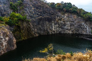 Çin Shanghai Botanik Bahçesi Karanlık Göl Dağ Cliff ve bulutlu yağmurlu gökyüzü arka plan ile