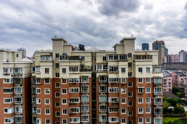 Çoklu seviyeli Highrise apartmanın bulutlu yağmurlu gökyüzü arka plan ile shanghai