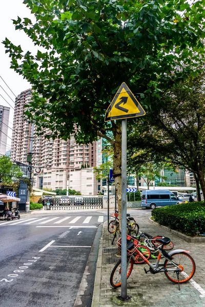 Shanghai Right Hand Bend Road Sign at Street with Tree and Bicycle
