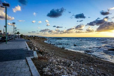 Lastik taşlı Beach Shore ile kara deniz ve gün batımında mavi gökyüzü arka plan