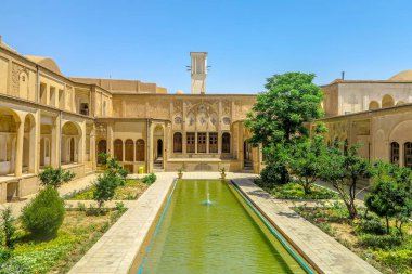 Çeşme gölet ve Windcatcher Kulesi ile kaşan Boroujerd tarihi evi Courtyard arkadan görünüm