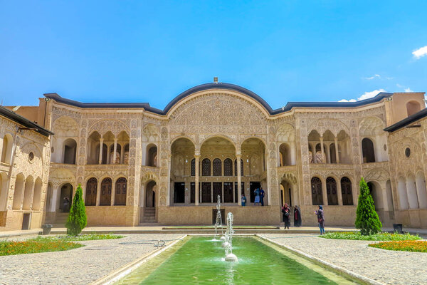 Кашан Табатабаи Исторический дом Кофедральный двор Фронтальная точка зрения с глухим прудом и людьми
