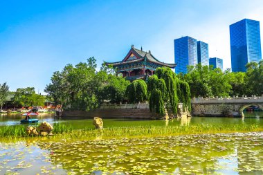 Urumçi insanların kamu Park Lake Pavilion nilüfer ve arka plan, Highrises