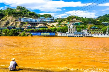 Lanzhou Sarı Nehir Çinli adam su camide arıyorum sahilinde oturan şapkalı