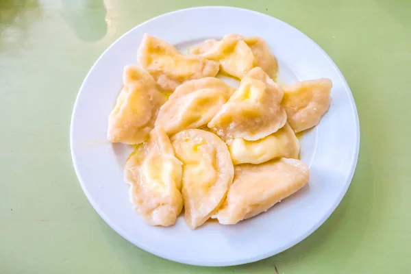 白い皿にチーズを詰めたウクライナの伝統的な空白のヴァレーヌィク — ストック写真