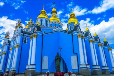 Kiev St. Michael'ın altın kubbeli manastır kilisesi yanında bir çapraz tutarak bir Aziz heykeli ile