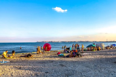 Odessa Luzanivka plaj rahatlatıcı yüzme ve güneşlenme insanlarla günbatımı sırasında deniz manzarası