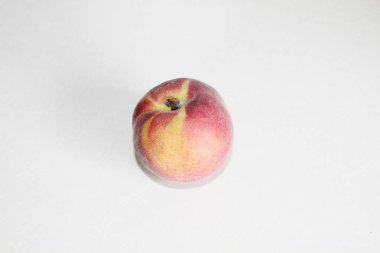 Beyaz arka plan üzerinde masanın üzerinde yatan şeftali