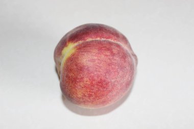 Beyaz arka plan üzerinde masanın üzerinde yatan şeftali