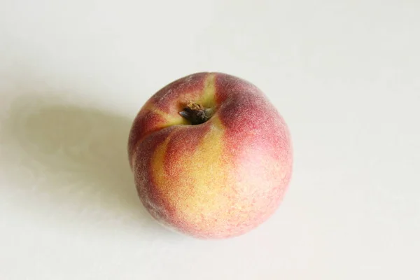 Персики лежат на столе на белом фоне — стоковое фото