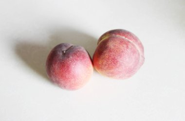 Beyaz arka plan üzerinde masanın üzerinde yatan şeftali