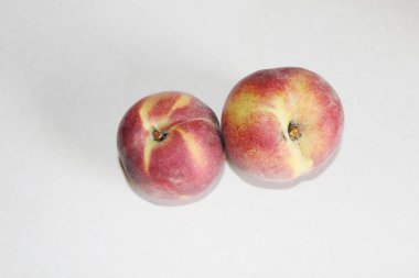 Beyaz arka plan üzerinde masanın üzerinde yatan şeftali