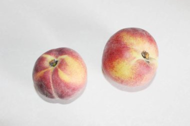 Beyaz arka plan üzerinde masanın üzerinde yatan şeftali