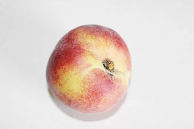 Beyaz arka plan üzerinde masanın üzerinde yatan şeftali