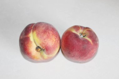 Beyaz arka plan üzerinde masanın üzerinde yatan şeftali