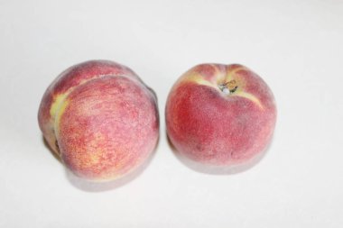 Beyaz arka plan üzerinde masanın üzerinde yatan şeftali