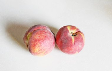 Beyaz arka plan üzerinde masanın üzerinde yatan şeftali