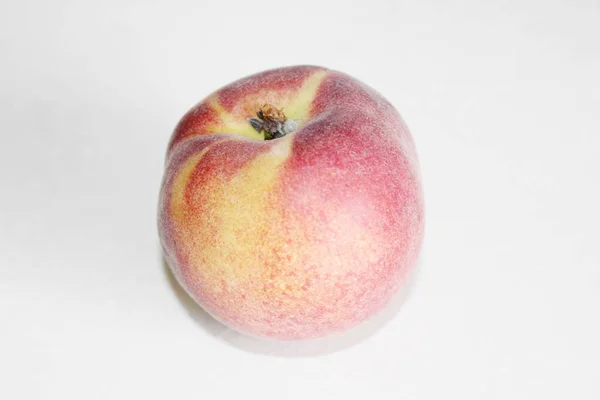 Персики лежать на столі на білому тлі — стокове фото