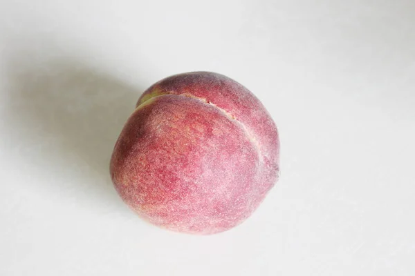 Perziken liggend op de tafel op een witte achtergrond — Stockfoto