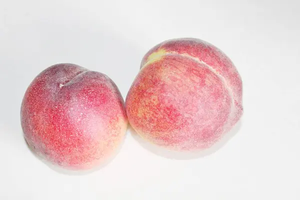 Pêches allongées sur la table sur un fond blanc — Photo