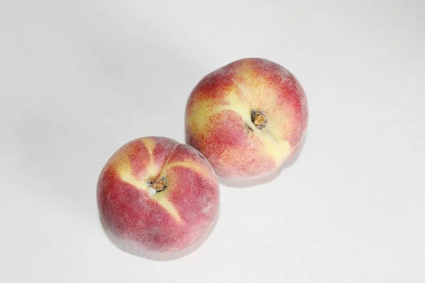 Pêches allongées sur la table sur un fond blanc — Photo