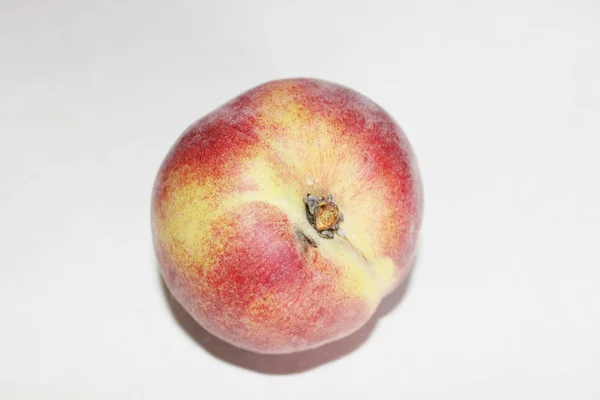 Персики лежат на столе на белом фоне — стоковое фото